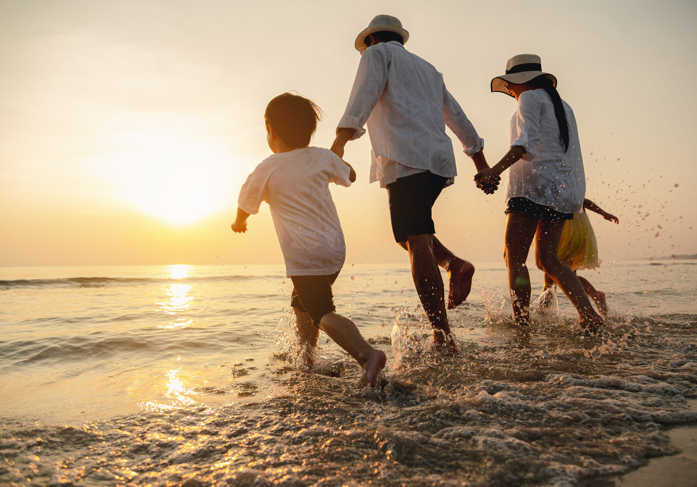 Happy asian family at consisting father, mother,son and daughter having fun playing beach in summer vacation on the beach.Happy family and vacations concept.